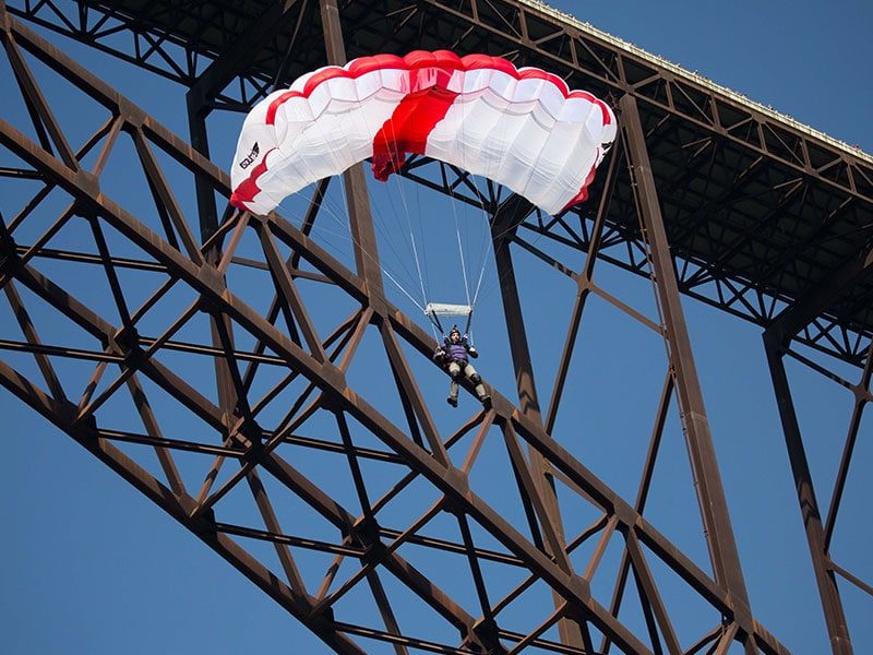 Paraglider flying under the New River Gorge Bridge in West Virginia.
