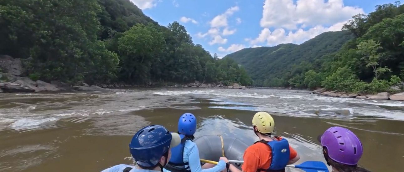 Group of rafters navigating the rapids in New River Gorge.